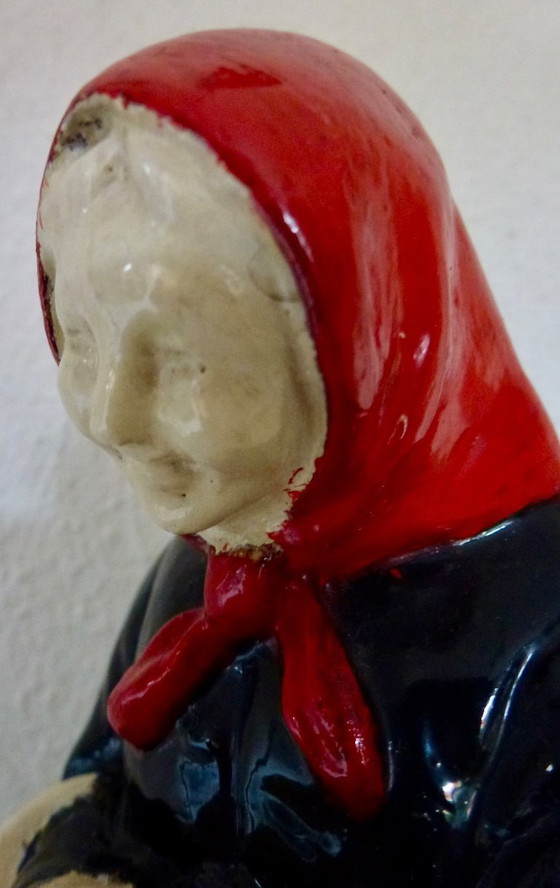 Image 1 of A set of decorative bookends depicting an elderly couple sitting on chairs.