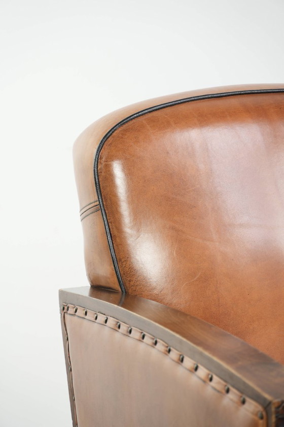 Image 1 of Unieke schapenleren art Deco fauteuil met mooi houtsnijwerk en zwarte biezen