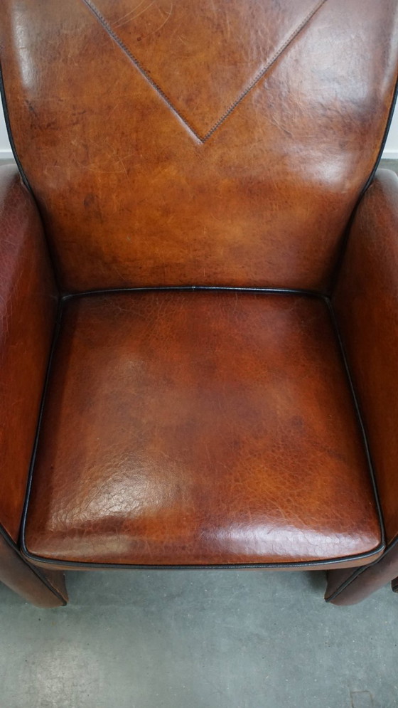 Image 1 of 4 x Vintage schapenleren eetkamerstoel met zwarte biezen op wieltjes