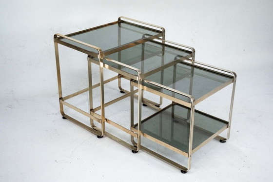 Image 1 of Ensemble de trois tables d'appoint gigognes en aluminium doré et verre – Italie, années 1970