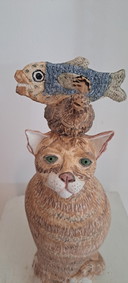 Escultura de cerámica de un gato con compañeros de juego.