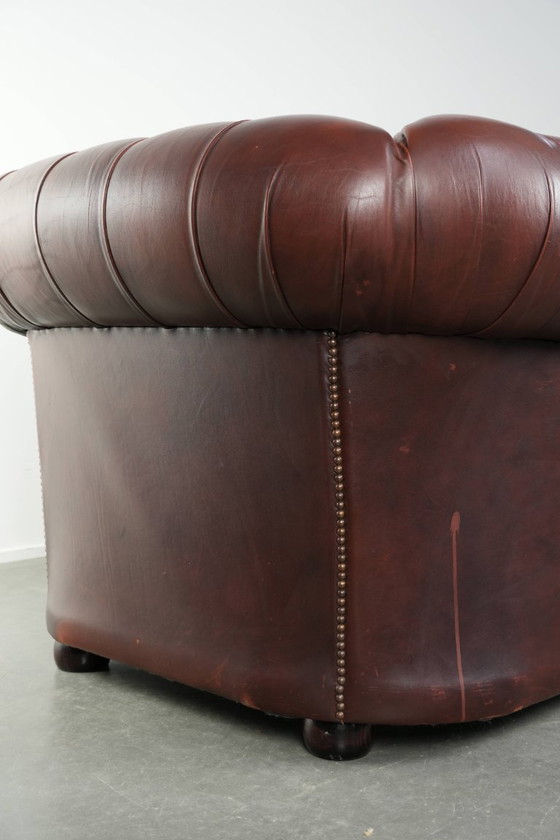 Image 1 of Beautiful red/brown cowhide Chesterfield armchair in a classic English style
