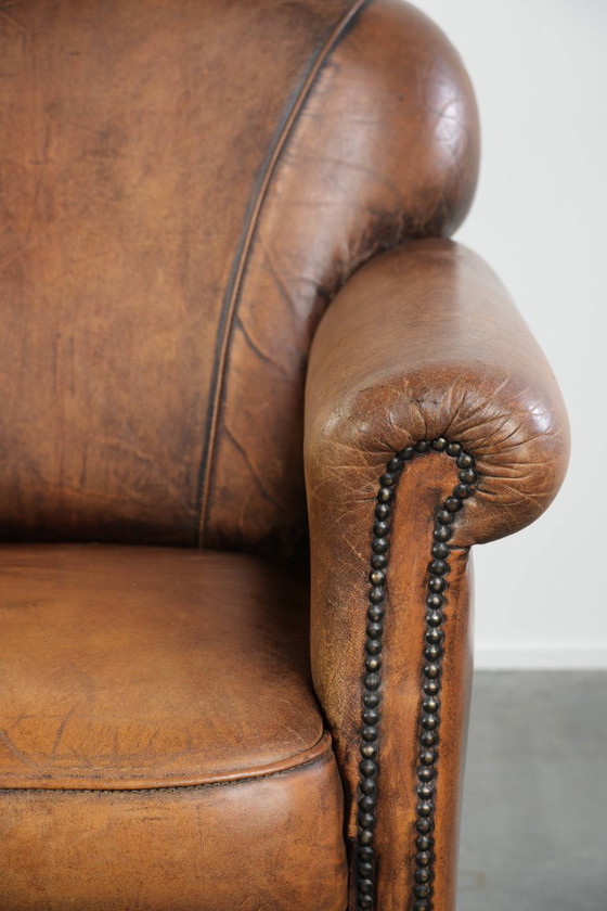 Comoda poltrona in pelle di pecora, dal carattere deciso, rifinita con borchie decorative e una splendida (photo 9 of 13)