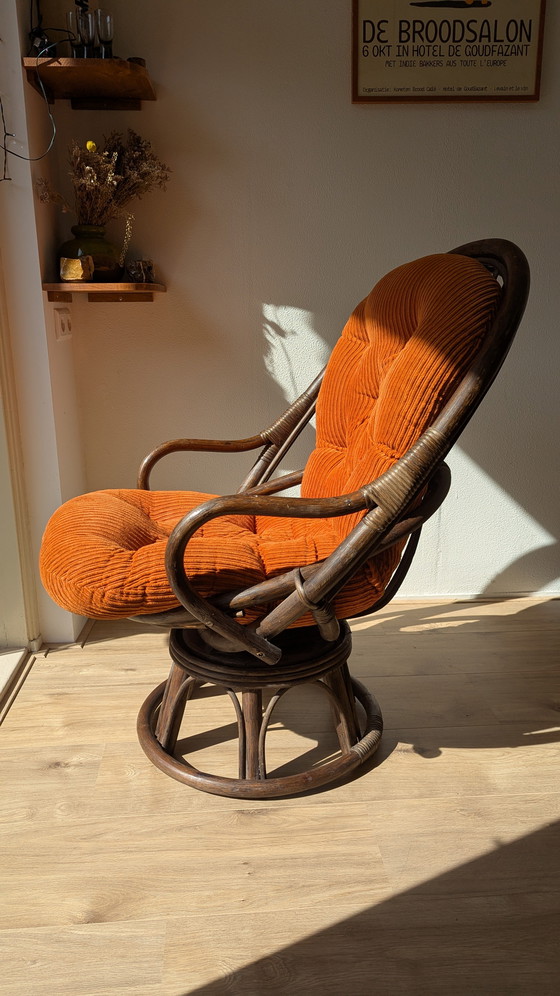 Image 1 of Draaibare rotanstoel uit de jaren 70 met oranje corduroy kussen