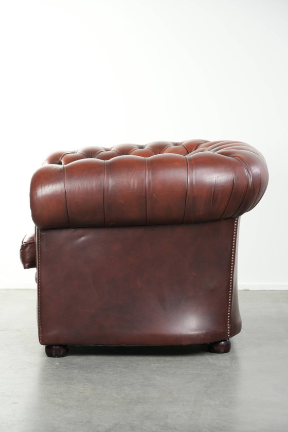 Image 1 of Beautiful red/brown cowhide Chesterfield armchair in a classic English style