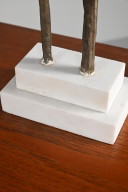 Tall sculpture on a marble pedestal