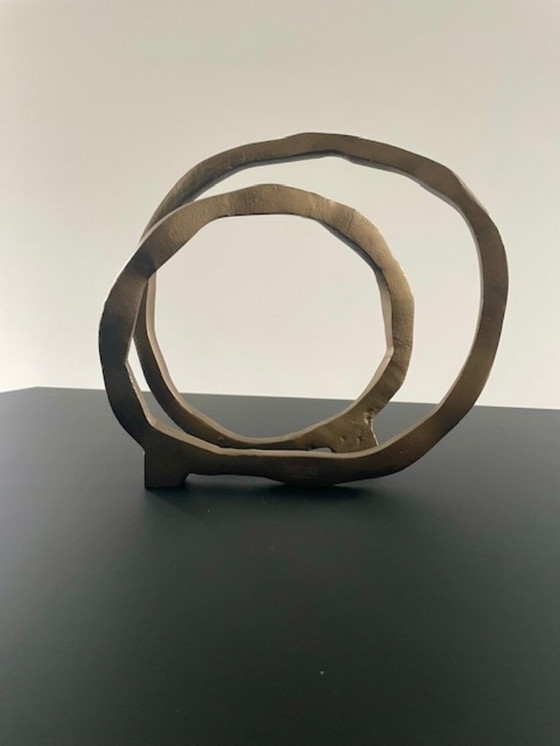 Image 1 of Escultura de diseño con forma de anillo abierto en oro mate.