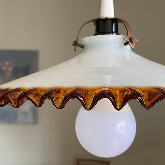 Image 1 of Antique pendant light with a white opaline glass shade and a golden caramel wavy edge