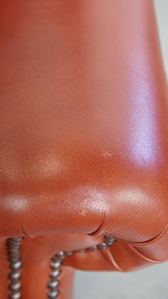 Image 1 of Elegante en comfortabele gladde Engelse rundleren chesterfield oorfauteuil met sierlijke pootjes