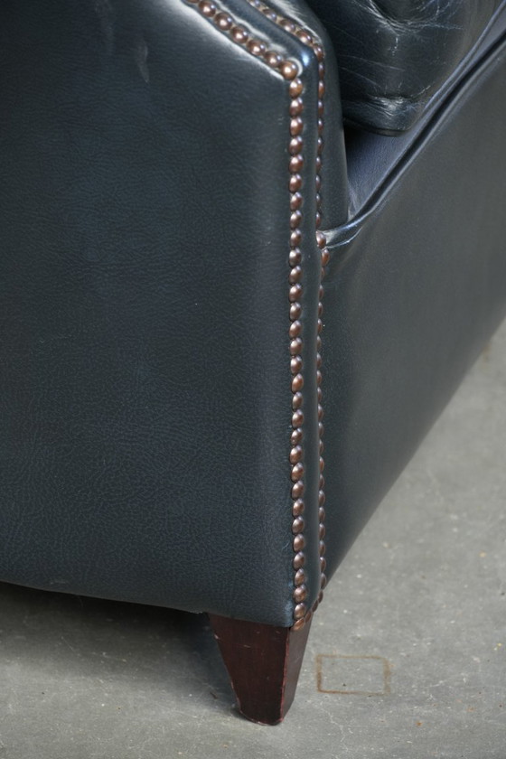 Image 1 of 2 comode poltrone club in pelle bovina blu scuro dal design unico e senza tempo.