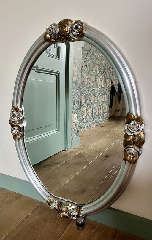 Ovale barokspiegel met zilverkleurige lijst/gouden bloemen