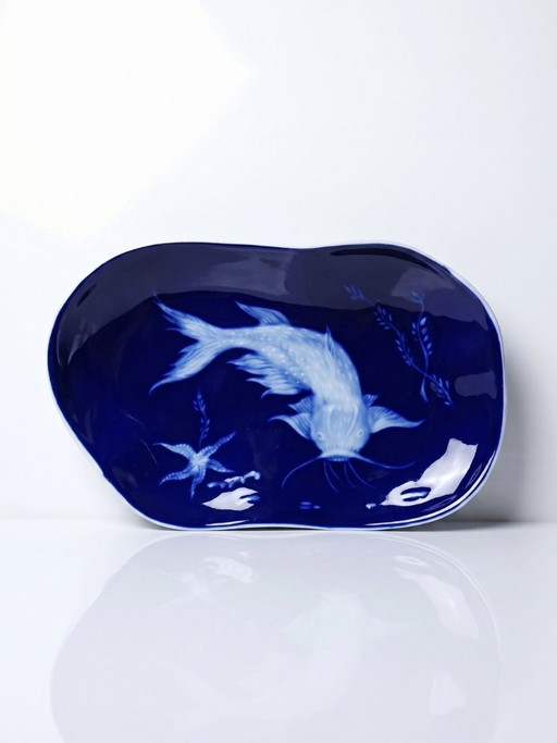 Plato pequeño de porcelana de Limoges con esmalte azul y decoración de peces al estilo japonés.