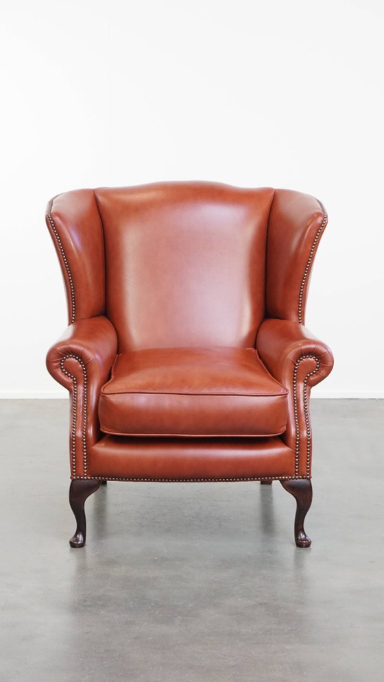 Image 1 of Elegante en comfortabele gladde Engelse rundleren chesterfield oorfauteuil met sierlijke pootjes