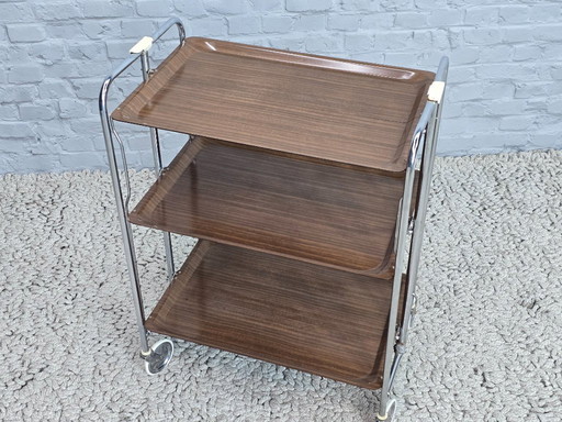 Vintage Foldable and Mobile Chrome Steel 3 Faux Wood Layers ‘Dinett’ Serving Trolley by Gerlinol, Germany, 1970s. 