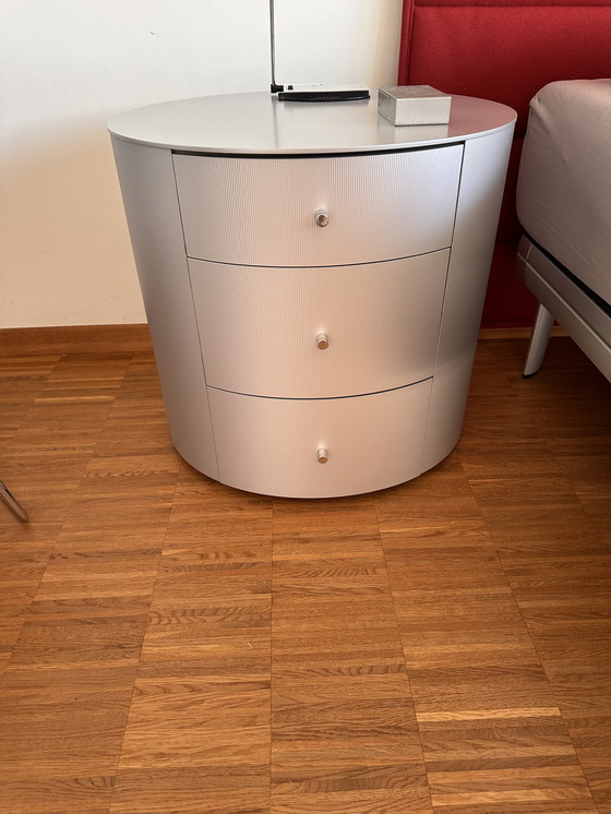 Image 1 of Comodino ovale in legno massello con rivestimento in alluminio spazzolato opaco