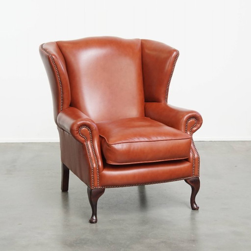 Elegante en comfortabele gladde Engelse rundleren chesterfield oorfauteuil met sierlijke pootjes