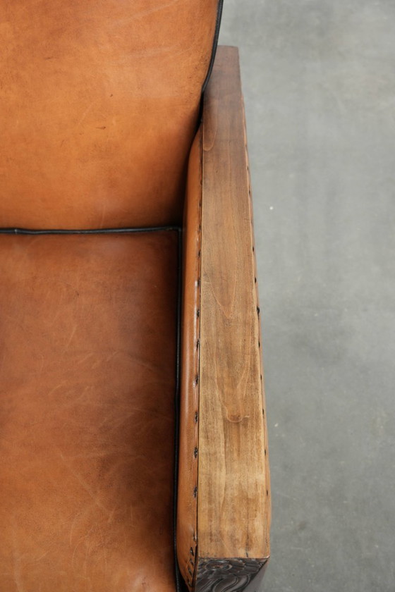 Image 1 of Schapenleren art Deco fauteuil met mooi houtsnijwerk en zwarte biezen