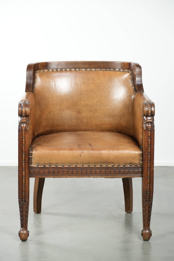Image 1 of Antique armchair of sheepskin and wood with decorative nails and beautiful woodwork