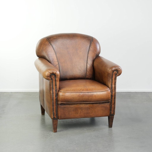 Comoda poltrona in pelle di pecora, dal carattere deciso, rifinita con borchie decorative e una splendida patina. – fauteuils