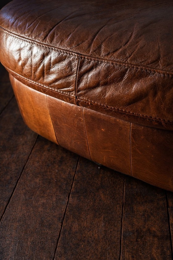 Image 1 of POLTRONA CHESTERFIELD CON POUF IN PELLE PATINA COGNAC