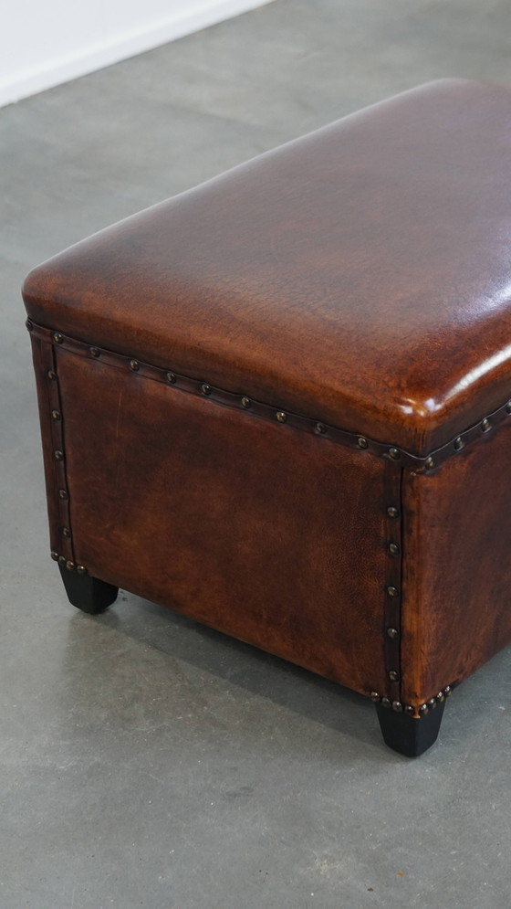 Image 1 of Cognac-kleurige schapenleren hocker met siernagels