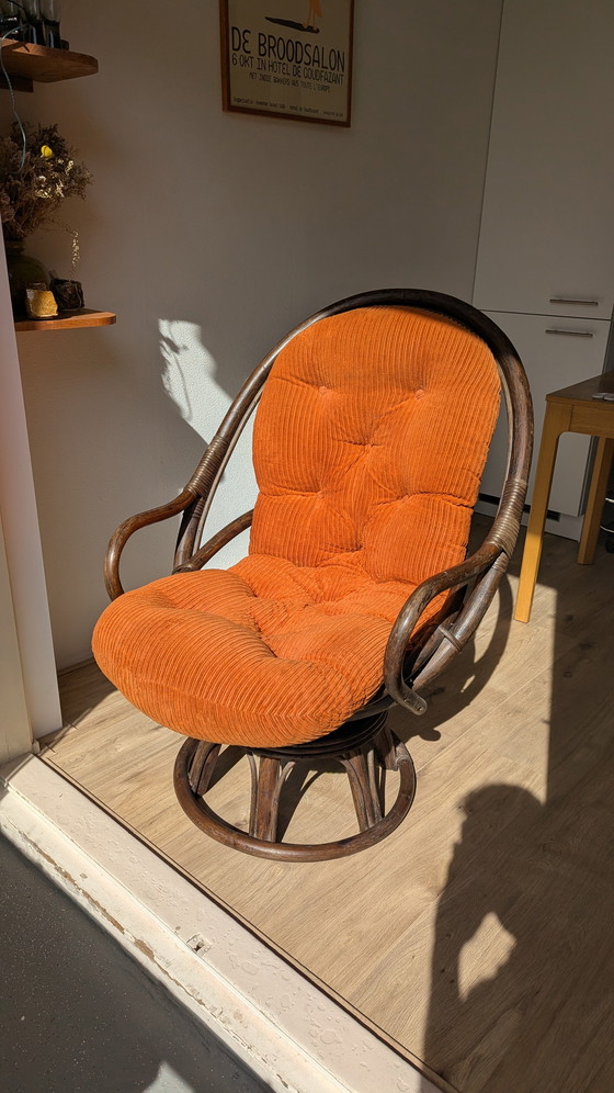 Image 1 of Draaibare rotanstoel uit de jaren 70 met oranje corduroy kussen