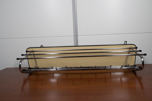 Perchero vintage con pared trasera de color amarillo.