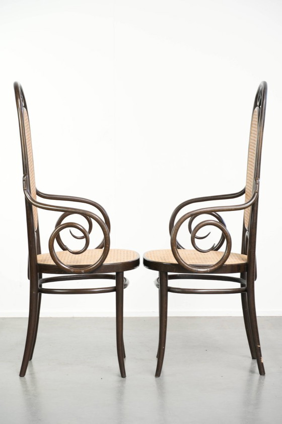 Image 1 of 2 chaises vintage originales Thonet, modèle Long John, avec accoudoirs, dossier haut, assise et dossier en sangles.