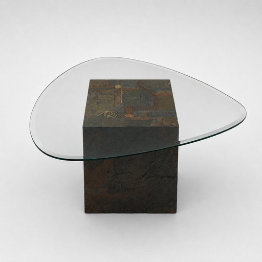 Mesa de centro de diseño exclusivo con base de piedra natural y tablero de cristal orgánico.