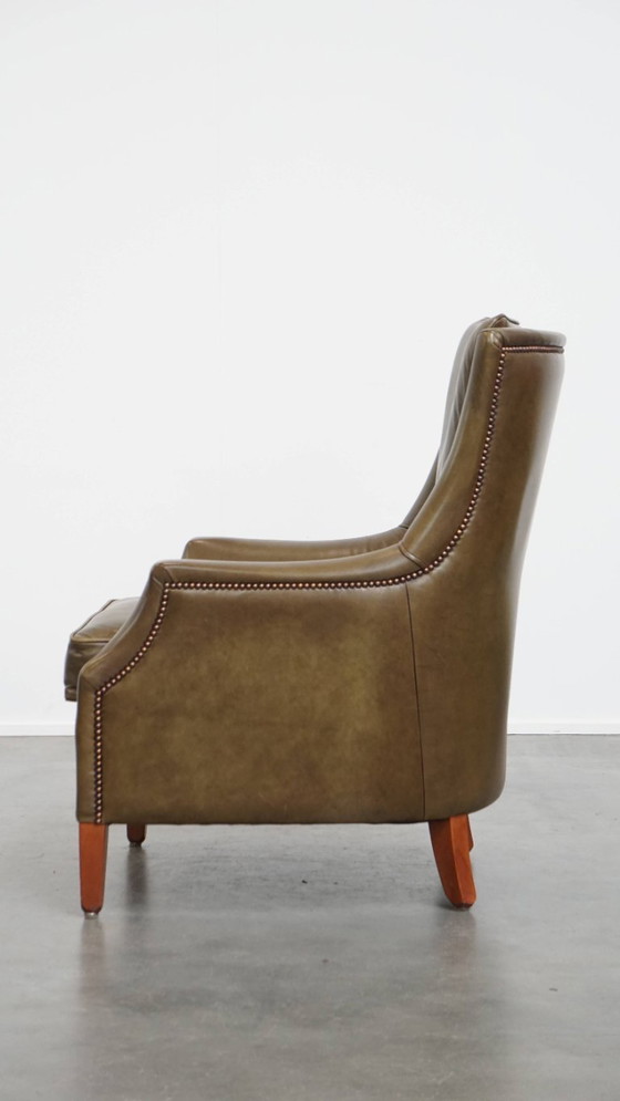 Image 1 of Poltrona in pelle di mucca verde oliva rifinita con chiodi decorativi