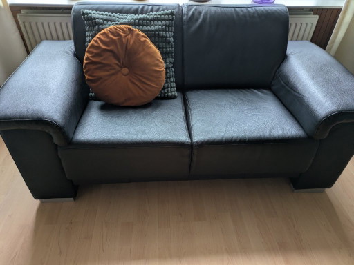 Schwarzes Ledersofa mit Accessoires