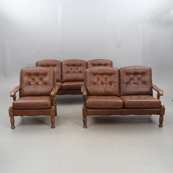 Image 1 of A vintage brown three-piece sofa set in leather with wooden armrests and turned legs, comprising a 1-seater, 2-seater and 3-seat