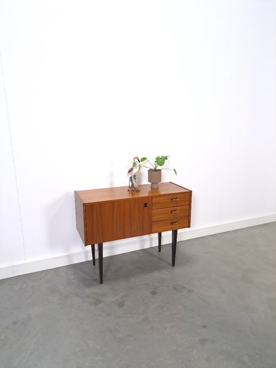 Image 1 of Mid-Century teak kastje op hoge zwarte poten met lades