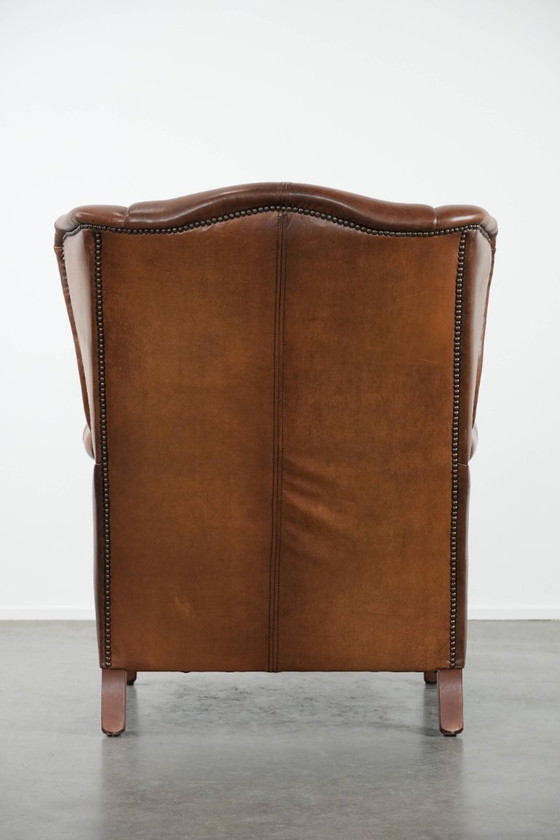 Image 1 of Tijdloze cognac kleurige oorfauteuil in Engelse stijl gemaakt van rundleer afgewerkt met siernagels
