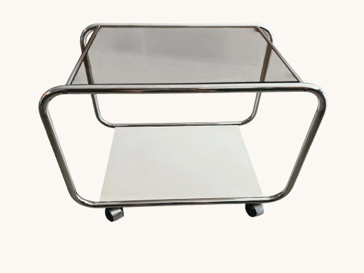 Vintage Space Age side table made of chrome and smoked glass. Sculptural 70s design with wheels.