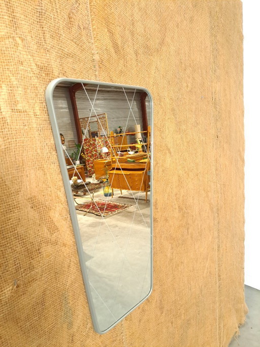 Spiegel met grijze kunststof rand en witte lijnen in het glas