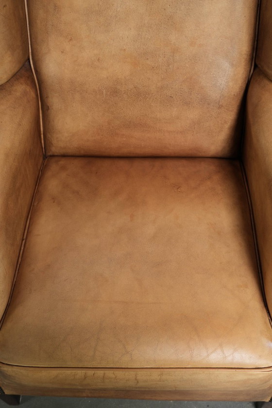 Image 1 of Dos hermosos sillones orejeros de piel de vaca clara con un estilo inglés atemporal y gran comodidad.