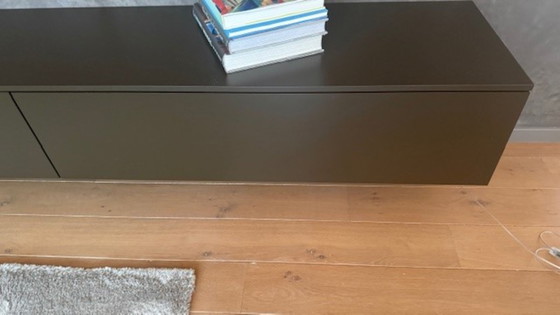 Image 1 of brown wall cupboard (possibly for under TV) with 3 folding doors