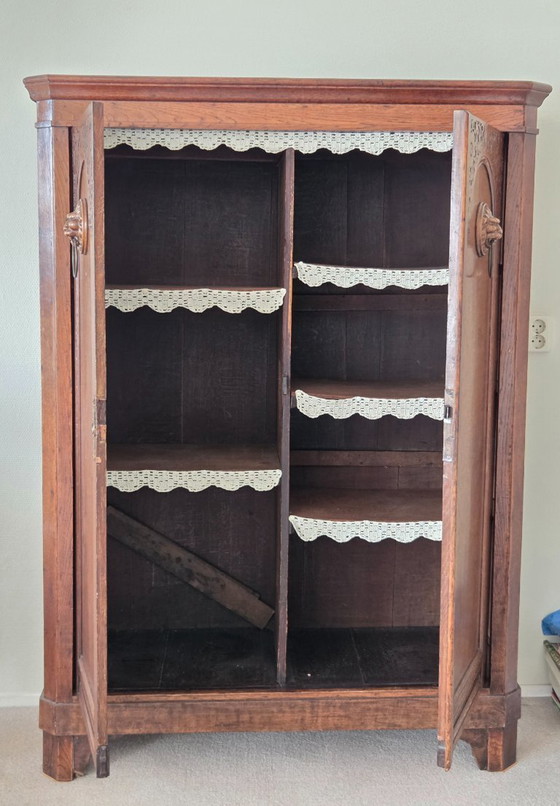 Image 1 of Armoire ancienne en chêne ornée de têtes de lion