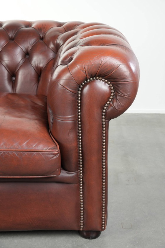 Image 1 of Beautiful red/brown cowhide Chesterfield armchair in a classic English style