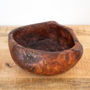 Ciotola rustica in legno intagliata a mano con nodi, ricavata da un tronco d'albero cavo.