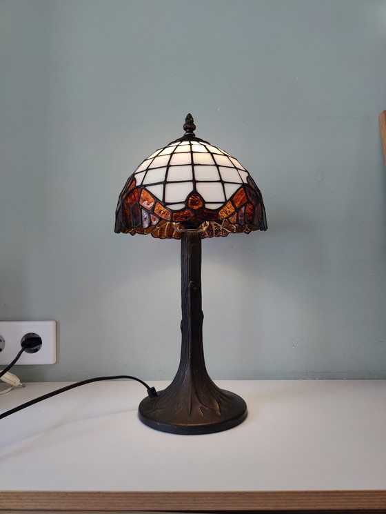 Image 1 of Lámpara de mesa estilo Tiffany con pantalla de vidrieras y base de bronce.
