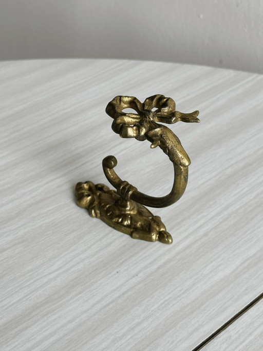 Small coat hook in gilded metal with bow motif