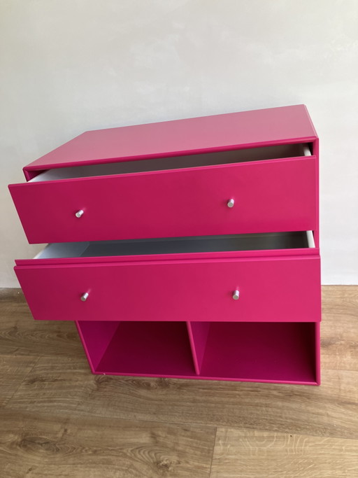 Módulo de muebles original Montana con cajones y compartimentos abiertos en color rosa fucsia.