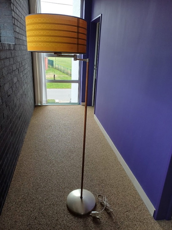 Image 1 of Dies ist eine Stehlampe aus Walnussholz im Mid-Century-Modern-Stil mit einem ockergelben Stoffschirm.