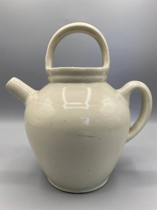 Borraccia vintage in gres smaltato color crema, con grande manico arcuato, beccuccio tubolare e senza coperchio. – servies