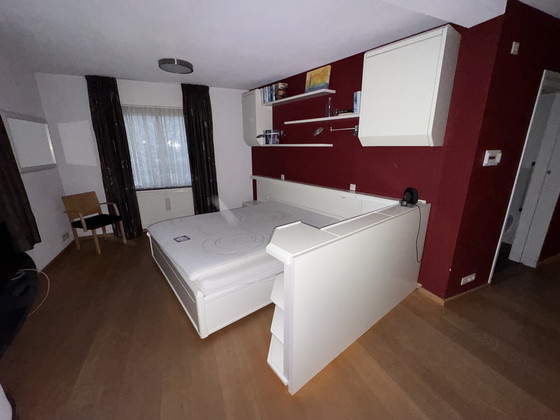 Image 1 of Hülsta Hülsta elektrisch verstelbaar bed met ombouw, bovenkasten, boekenplanken en spiegel. 