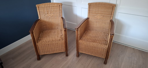 Juego de 2 sillones de ratán con reposabrazos de madera.