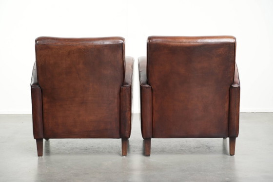 Image 1 of 2x dunkel cognacfarbene Schaffellsessel mit abgerundeten Formen und elegantem Design