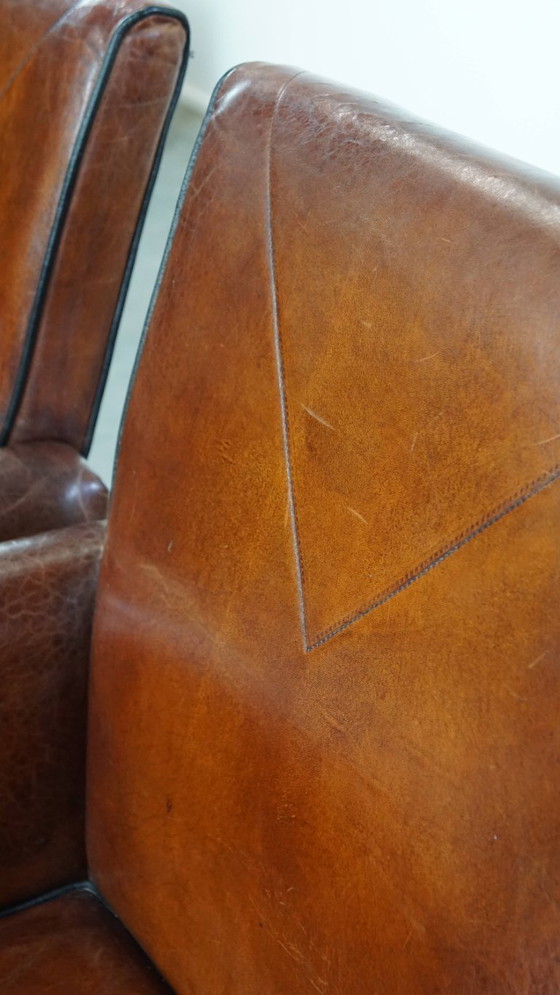 Image 1 of 2 x Vintage schapenleren eetkamerstoel met zwarte biezen op wieltjes